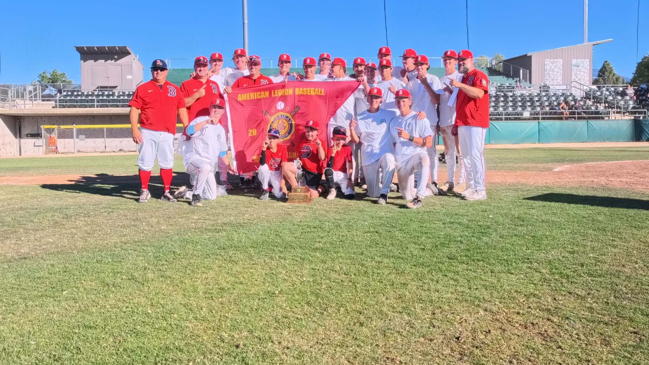 The Post 158 Barbers with the American Legion Baseball state championship banner and trophy.